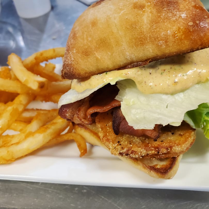 Crispy chicken sandwich with bacon, lettuce, and special sauce, served with golden french fries.